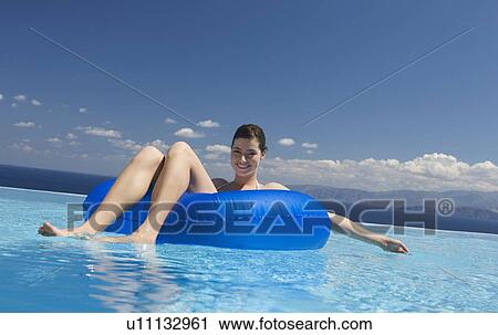 Stock Image - A woman relaxing in a pool. Fotosearch