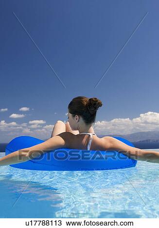 A woman relaxing in a pool View Large Photo Image Stock Image - A woman relaxing in a pool. Fotosearch