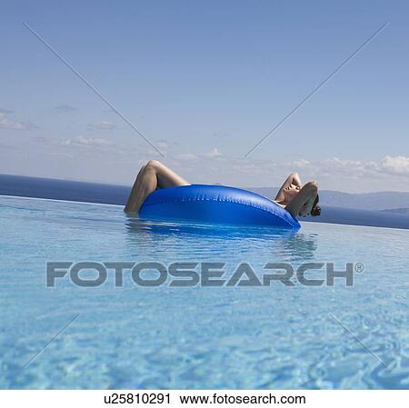 Stock Image - A woman relaxing in a pool. Fotosearch