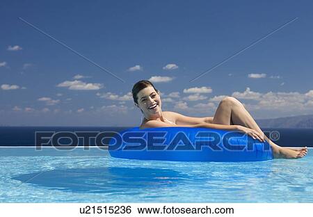 Stock Photograph - A woman relaxing in a pool. Fotosearch