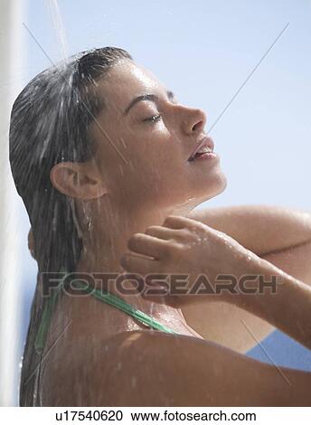 Stock Image - A woman relaxing in a shower. Fotosearch