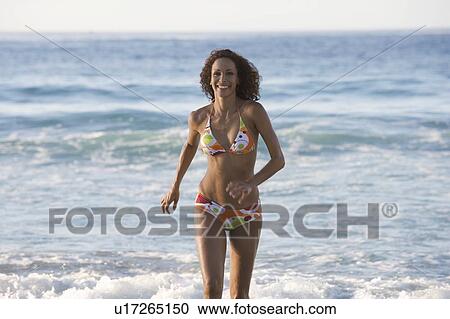 Stock Image - A woman running on the beach. Fotosearch