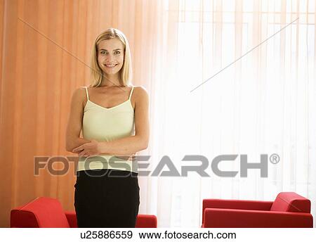Stock Photo - A woman standing in a room. Fotosearch