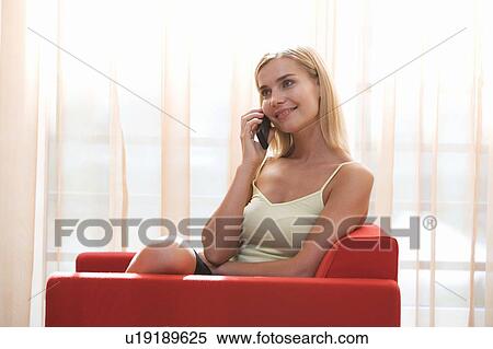 A woman talking on a mobile phone View Large Photo Image Stock Photography - A woman talking on a mobile phone. Fotosearch
