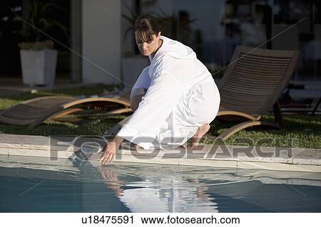A woman testing the temperature of a swimming pool View Large Photo Image Stock Image - A woman testing the temperature of a swimming pool. Fotosearch