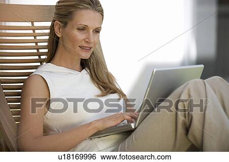 Stock Photograph - A woman using a laptop. Fotosearch