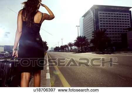 Stock Photo - A woman walking on the side of a road. Fotosearch