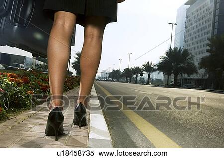 A woman walking on the side of a road View Large Photo Image Stock Photography - A woman walking on the side of a road. Fotosearch
