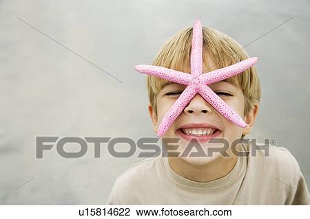 A young boy holding a starfish View Large Photo Image Stock Image - A young boy holding a starfish. Fotosearch