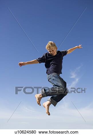 Stock Image - A young boy jumping. Fotosearch