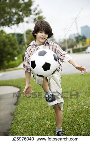 A young boy kicking football View Large Photo Image Stock Image - A young boy kicking football. Fotosearch