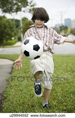 A young boy kicking football View Large Photo Image Stock Image - A young boy kicking football. Fotosearch