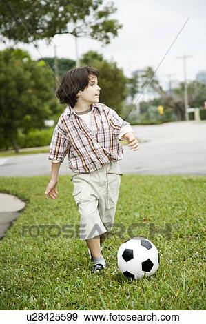A young boy kicking football View Large Photo Image Stock Photo - A young boy kicking football. Fotosearch