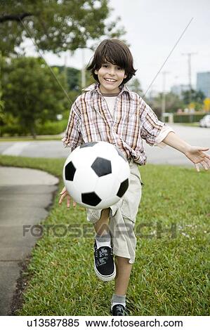 A young boy kicking football View Large Photo Image Stock Photography - A young boy kicking football. Fotosearch