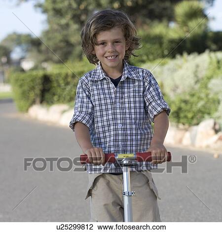 Stock Image - A young boy on a scooter. Fotosearch