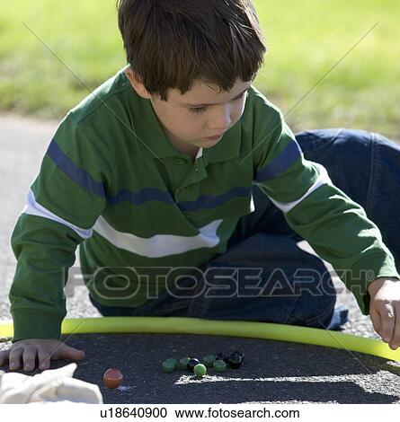 A young boy playing marbles View Large Photo Image Stock Image - A young boy playing marbles. Fotosearch