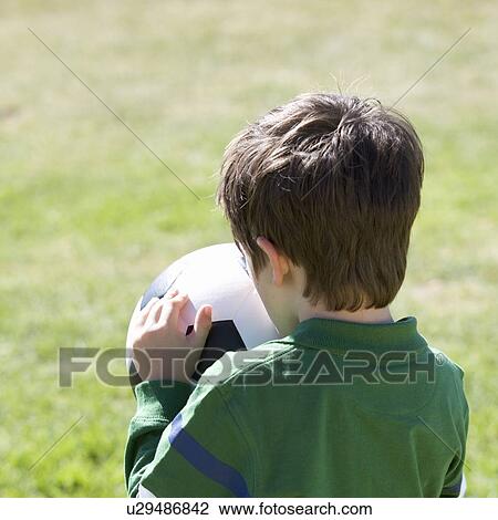 Stock Image - A young boy with a football. Fotosearch
