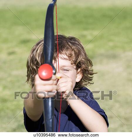 A young boy with a toy bow and arrow View Large Photo Image Stock Photograph - A young boy with a toy bow and arrow. Fotosearch