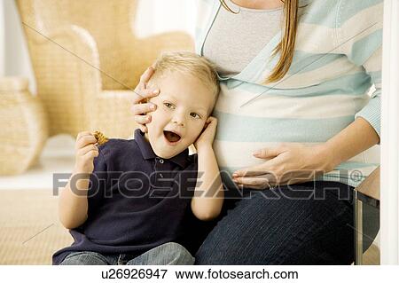 Stock Photo - A young boy with his pregnant mother. Fotosearch