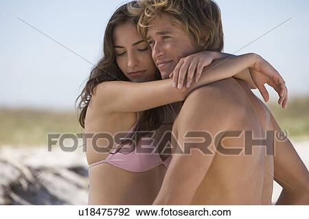 A young couple on a beach View Large Photo Image Stock Image - A young couple on a beach. Fotosearch