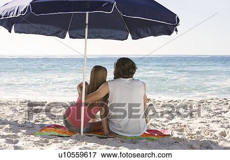 A young couple on a beach View Large Photo Image Stock Photo - A young couple on a beach. Fotosearch