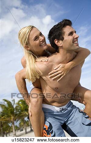 A young couple on a beach View Large Photo Image Stock Photo - A young couple on a beach. Fotosearch