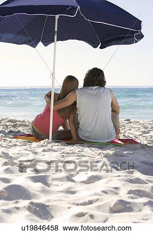 Stock Photo - A young couple on a beach. Fotosearch