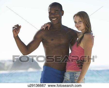 Stock Photo - A young couple on a beach. Fotosearch
