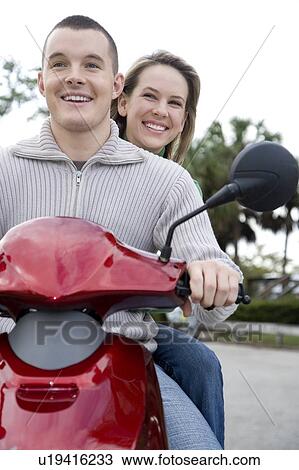 Stock Image - A young couple on a scooter. Fotosearch