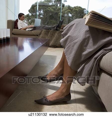 Stock Image - A young couple sitting in a living room. Fotosearch