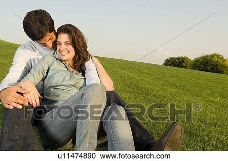 A young couple sitting in a park View Large Photo Image Stock Image - A young couple sitting in a park. Fotosearch