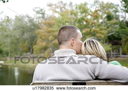A young couple sitting in a park View Large Photo Image Stock Photography - A young couple sitting in a park. Fotosearch