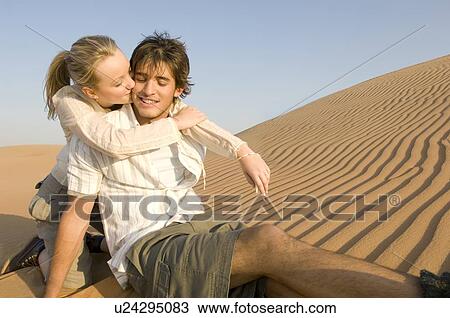 A young couple sitting in the desert View Large Photo Image Stock Image - A young couple sitting in the desert. Fotosearch