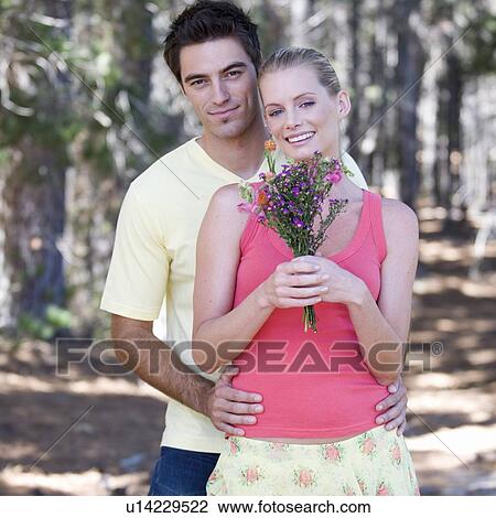 Stock Image - A young couple with a bouquet of flowers. Fotosearch