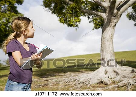 Stock Image - A young girl drawing a tree. Fotosearch
