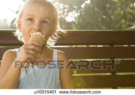 Stock Image - A young girl eating an ice cream. Fotosearch