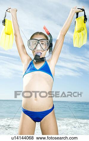 Stock Photo - A young girl in snorkeling gear on the beach . Fotosearch