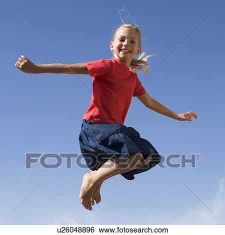 Stock Photograph - A young girl jumping. Fotosearch
