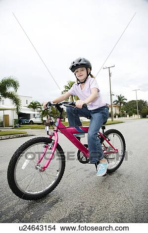 A young girl on a bike View Large Photo Image Picture - A young girl on a bike. Fotosearch