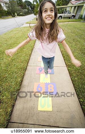 A young girl playing hopscotch View Large Photo Image Stock Image - A young girl playing hopscotch. Fotosearch