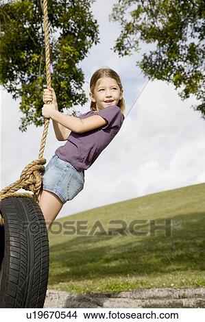 A young girl playing on a swing View Large Photo Image Picture - A young girl playing on a swing. Fotosearch