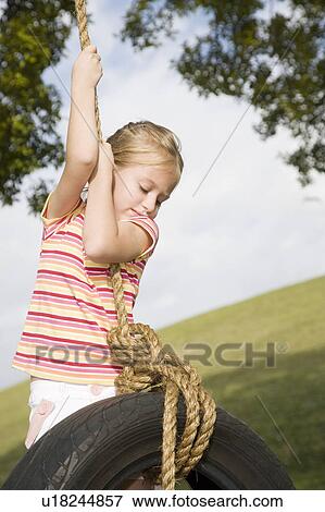A young girl playing on a swing View Large Photo Image Stock Photo - A young girl playing on a swing. Fotosearch