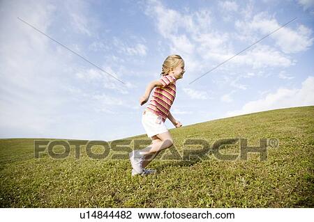 A young girl running across a hill View Large Photo Image Stock Image - A young girl running across a hill. Fotosearch