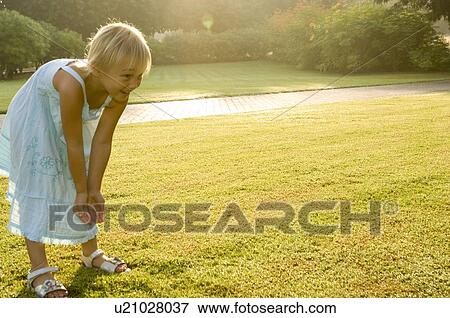 A young girl standing in a park View Large Photo Image Stock Photo - A young girl standing in a park. Fotosearch