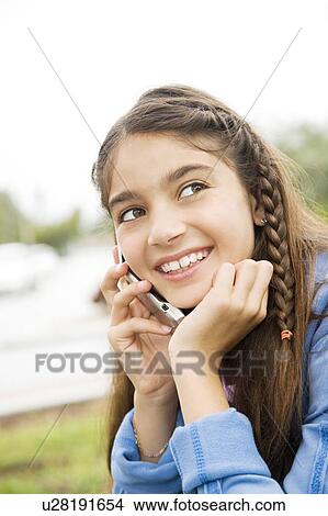A young girl using a mobile phone View Large Photo Image Picture - A young girl using a mobile phone. Fotosearch