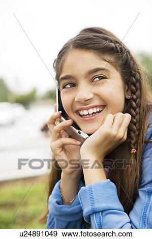 A young girl using a mobile phone View Large Photo Image Stock Photo - A young girl using a mobile phone. Fotosearch