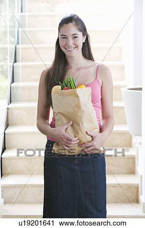 Stock Image - A young girl with a bag of shopping. Fotosearch