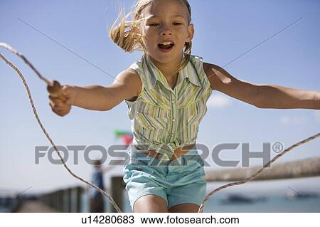 A young girl with a skipping rope View Large Photo Image Stock Image - A young girl with a skipping rope. Fotosearch
