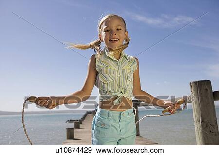 A young girl with a skipping rope View Large Photo Image Stock Photo - A young girl with a skipping rope. Fotosearch