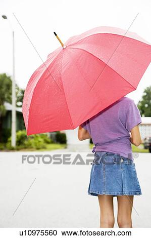 Stock Image - A young girl with an umbrella. Fotosearch